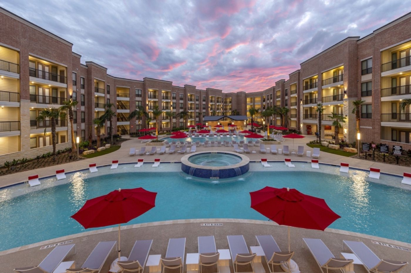Completed Katy Boardwalk Lofts courtyard and pool at sunset
