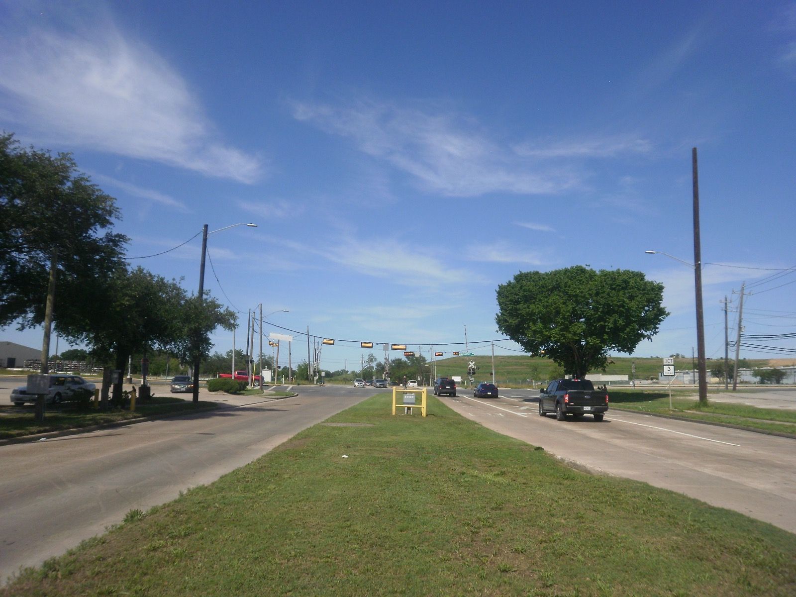 Fenced construction staging yard with crane along the alignment