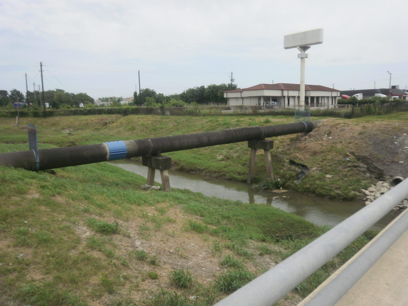 Large-diameter water line carried across a bayou on pile supports