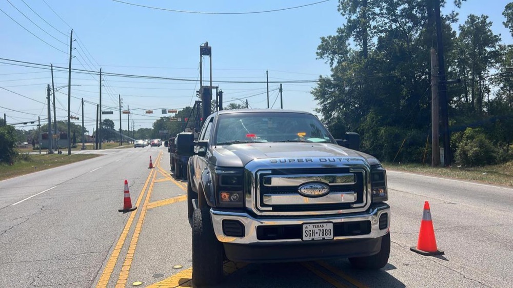 ATL crew operating the auger rig as traffic passes
