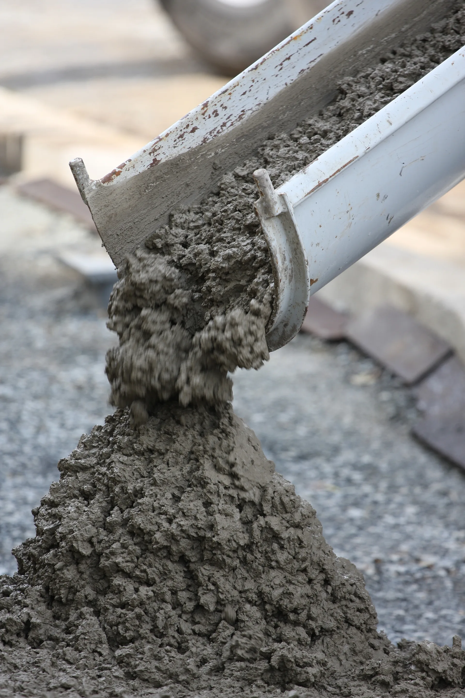 Concrete being poured from a chute at a job site